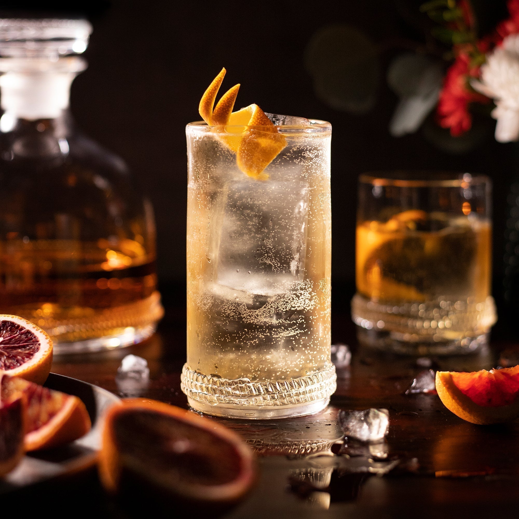 A high ball close-up of a cocktail with orange twist