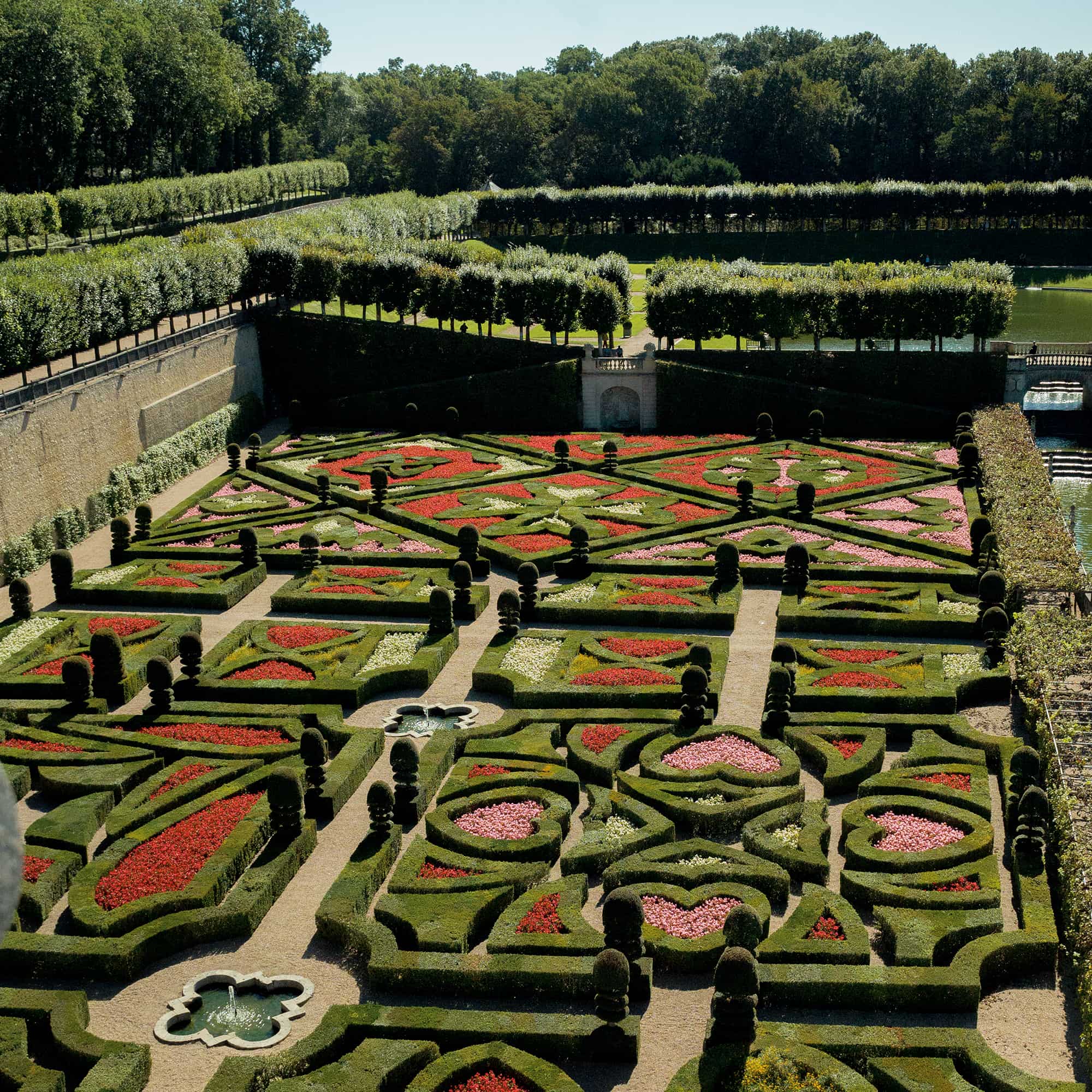Image of the garden of outside a chateau with red and pink flowers