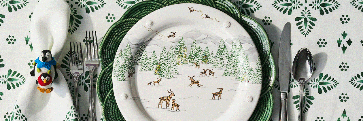 Moveable gif with set of decorative plates with winter Christmas scene design on a patterned tablecloth