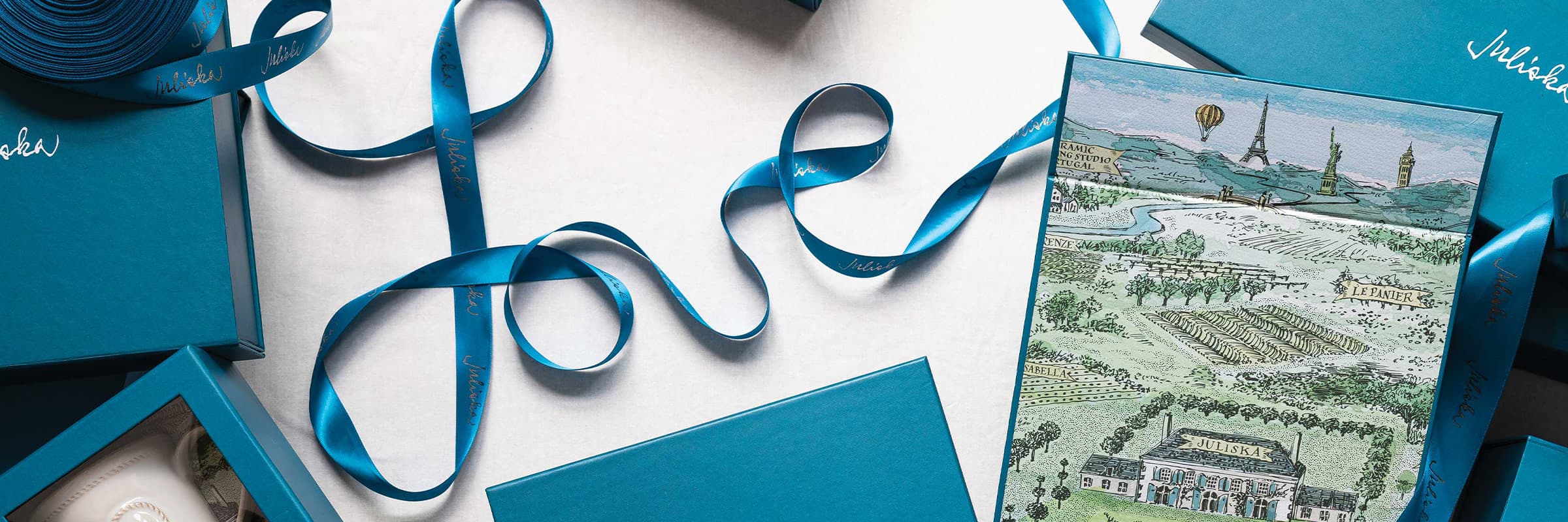 Teal gift boxes with Juliska logo on them.