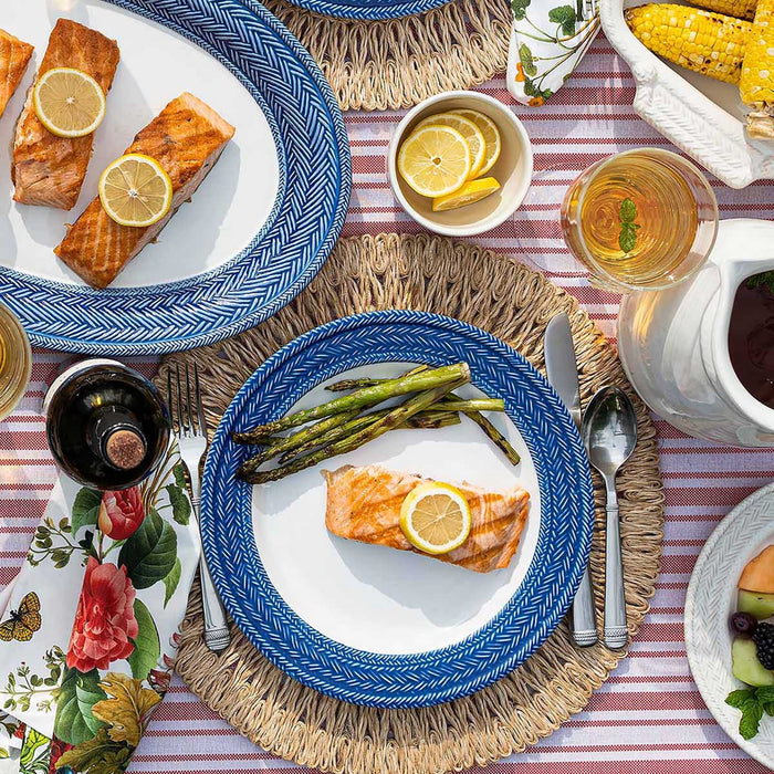 Le Panier dinner plate with salmon and asparagus on a red and white striped tablecloth. 