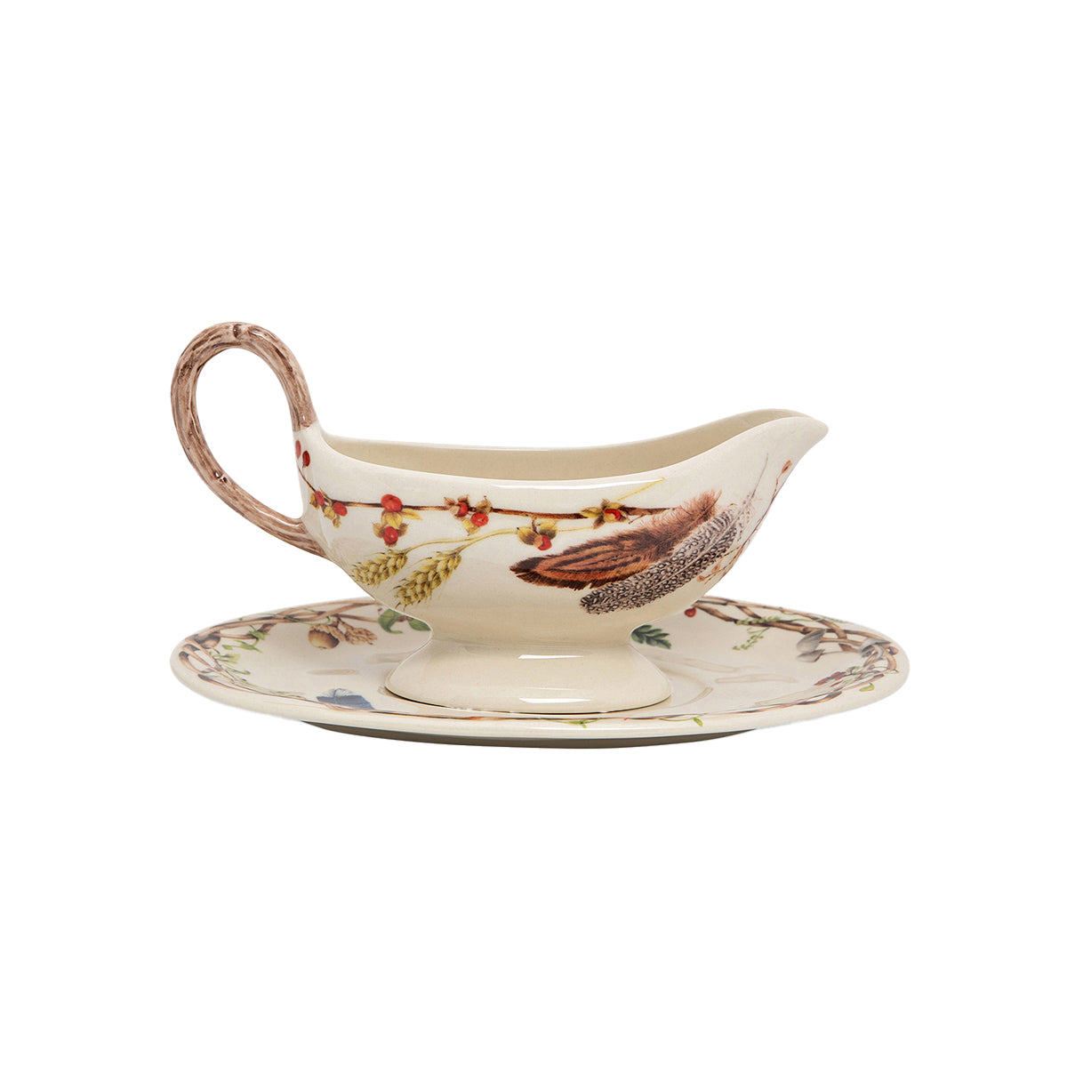 Sauce boat with handle painted to appear as a twig and the body painted with a design of flora and fauna. There is also a matching saucer.