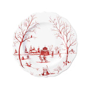 White plate with red artwork of figures skating on an ice-covered pond.