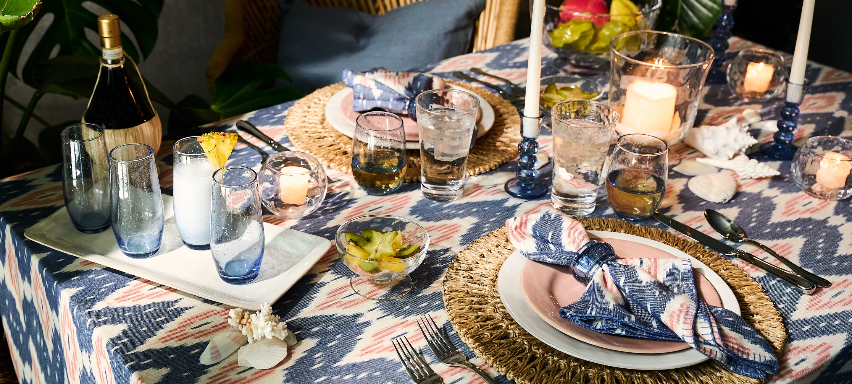 Elegant outdoor dining table setting with floral arrangements and luxe ceramics.