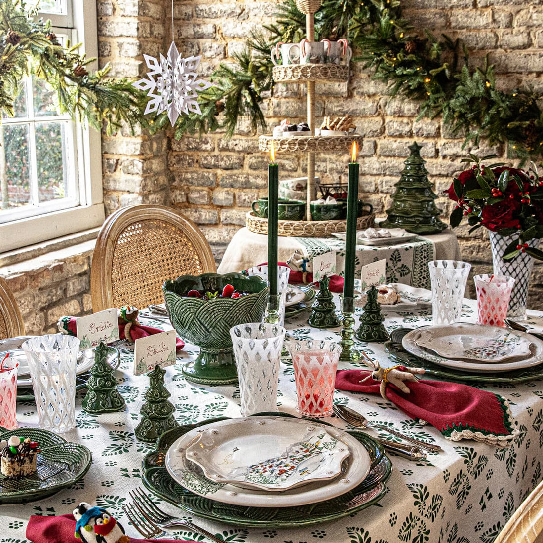 Decorative Christmas table setting with green and red accents in a rustic room.