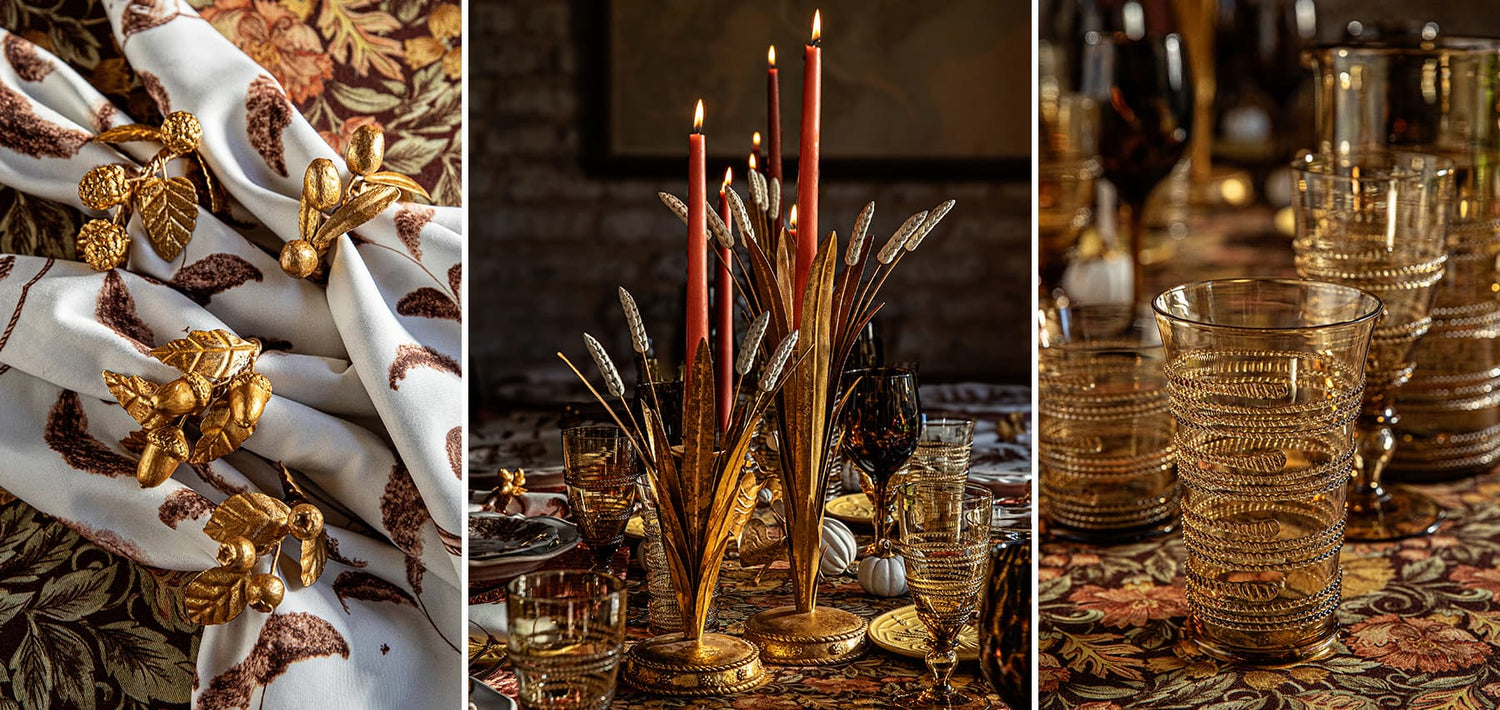 Decorative table setting with gold and red candles, glasses, and patterned tablecloth.