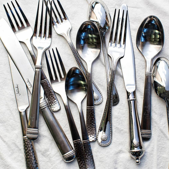 Flatware on a white tablecloth.