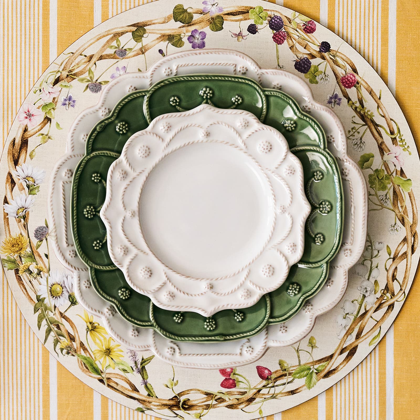 Square image featuring whitewash and basil Jardin Du Monde plates stacked on a meadow walk placemat