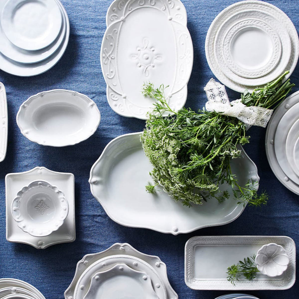 Overhead image of white platters on a blue tablecloth.