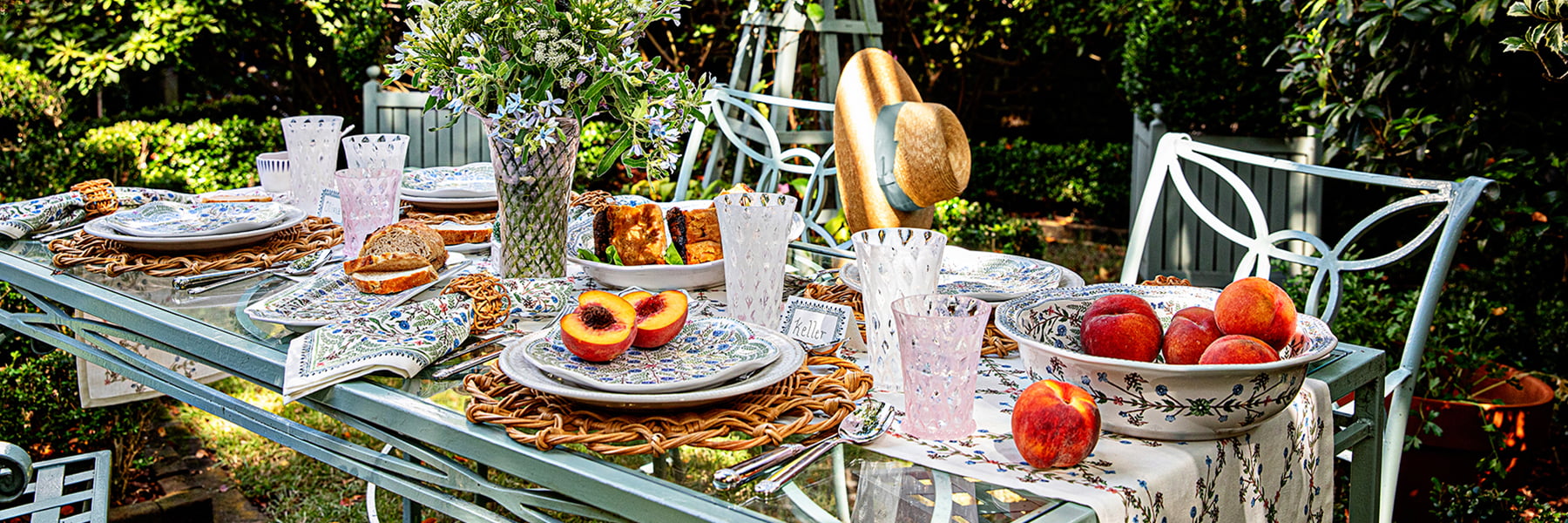 Al fresco tablescape in the middle of a garden featuring trellis glassware and villa seville ceramics