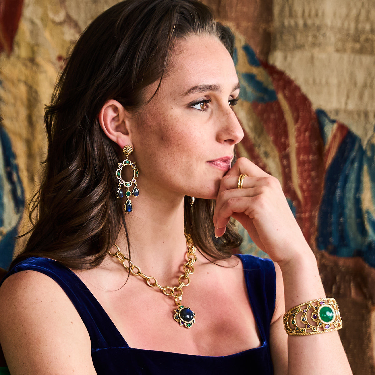 Young woman posing wearing blue and green jewelry.