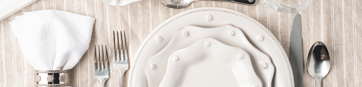 Whitewash dinner plate sits on top of a chambray Tuileries Garden placement and is adorned with a scalloped Chambray Blue dessert plate.
