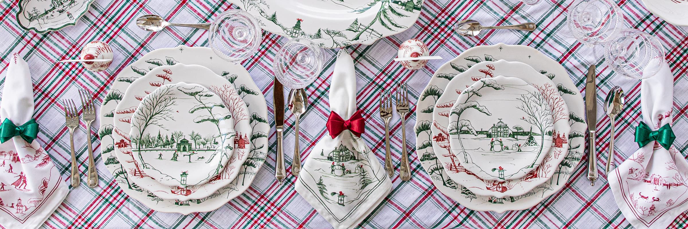 Country Estate Winter Frolic Ruby and Evergreen plates within a place setting on a merry tartan tablecloth