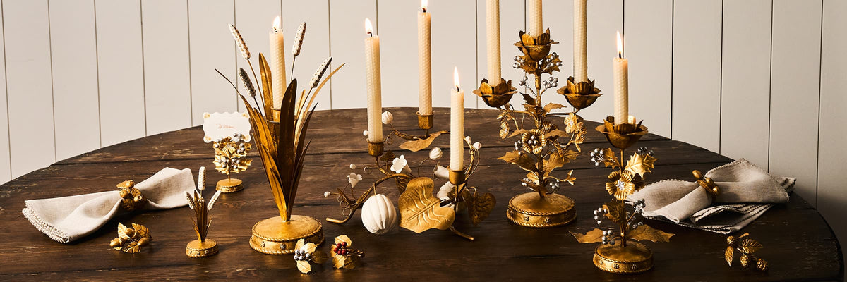 Thanksgiving table setting with pumpkins, place cards, and decorative napkins.
