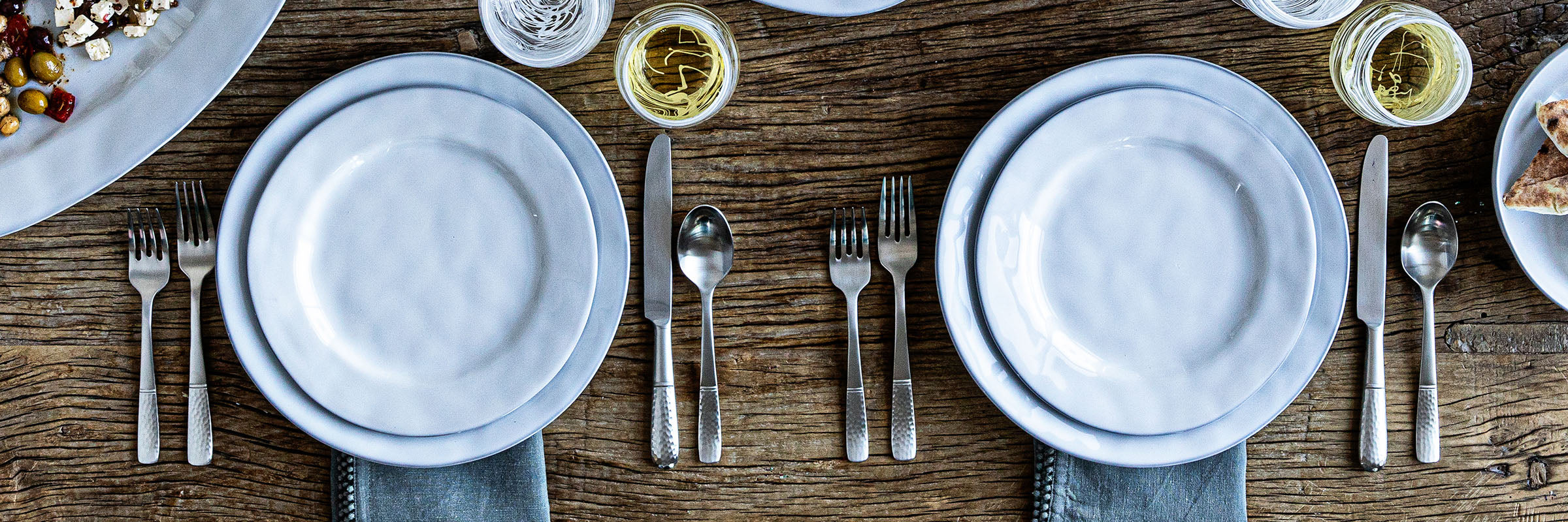 Classic shaped plate in a white truffle glaze showcased within a place setting