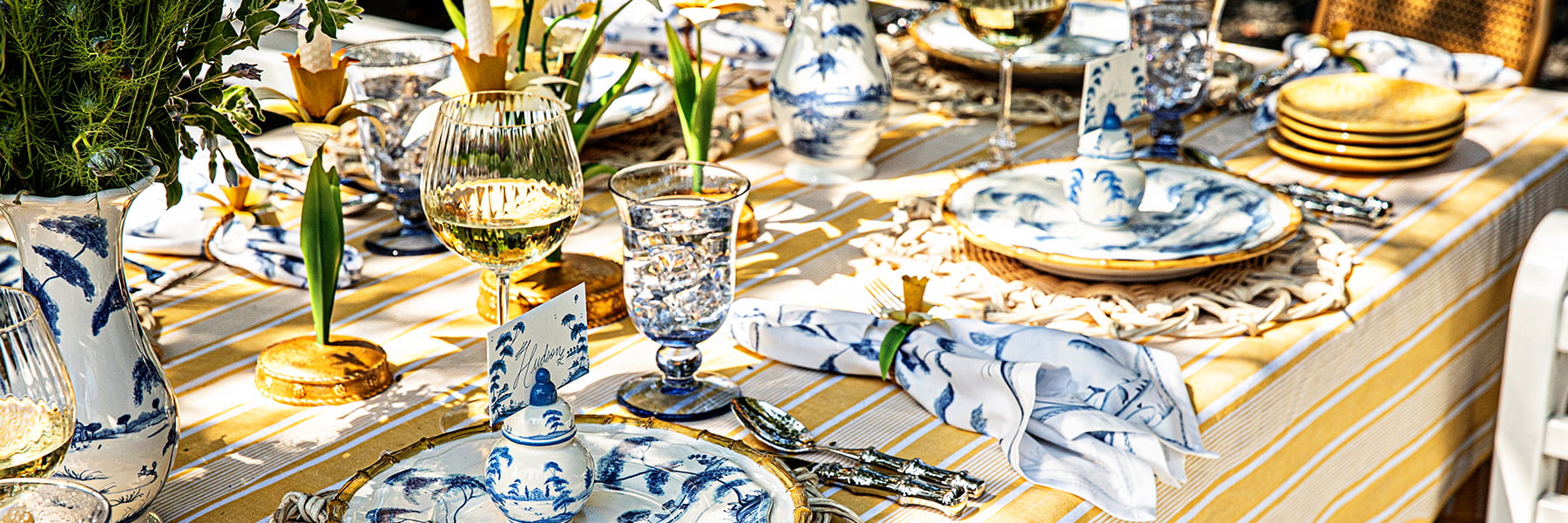 Image featuring a mix of yellow and blue plates and serveware amongst an outdoor tablescape