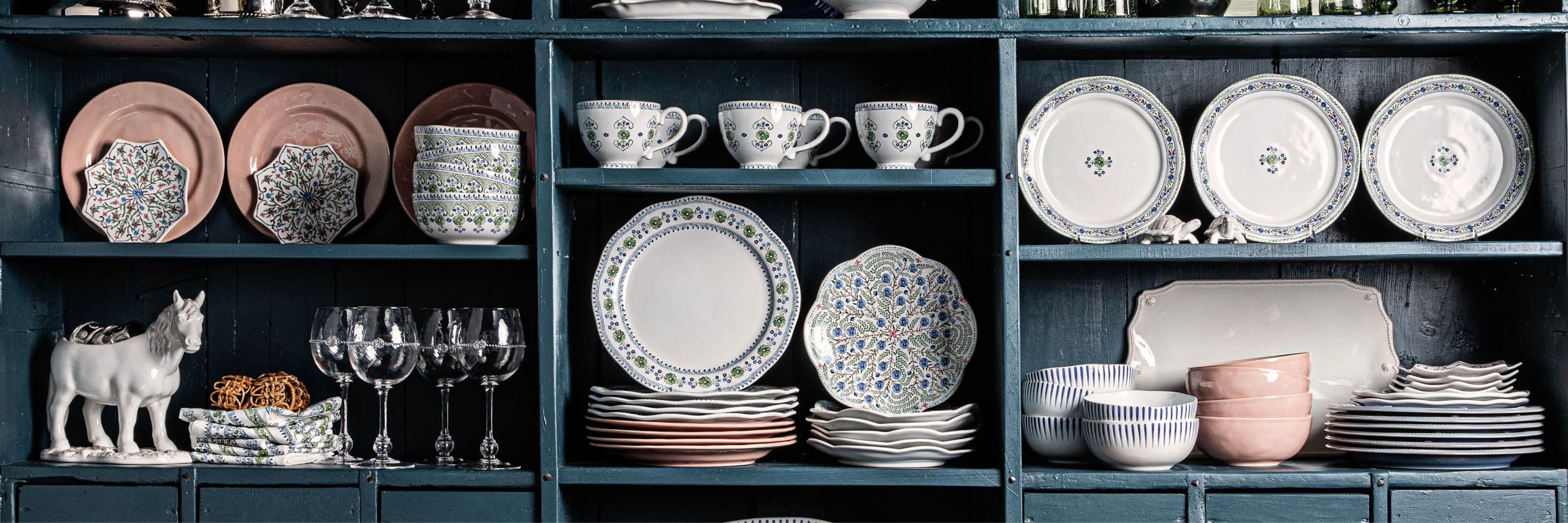 Blue cabinet showcasing Puro Blush, Villa Seville and Sitio Stripe Delft Blue collections.