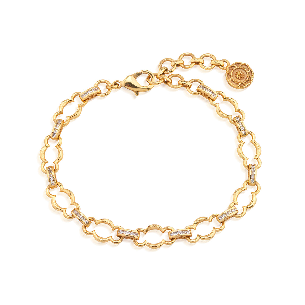 A gold chain bracelet with interlocking scalloped links, small clear stones set along parts of the chain, a lobster clasp, and an adjustable extender chain with a round branded tag, shown on a plain white background.