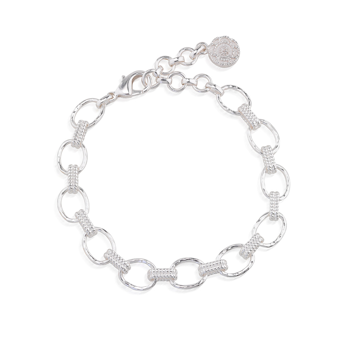 A silver link bracelet featuring alternating polished oval links and textured barrel links, with a lobster clasp and a round branded tag, shown on a plain white background.