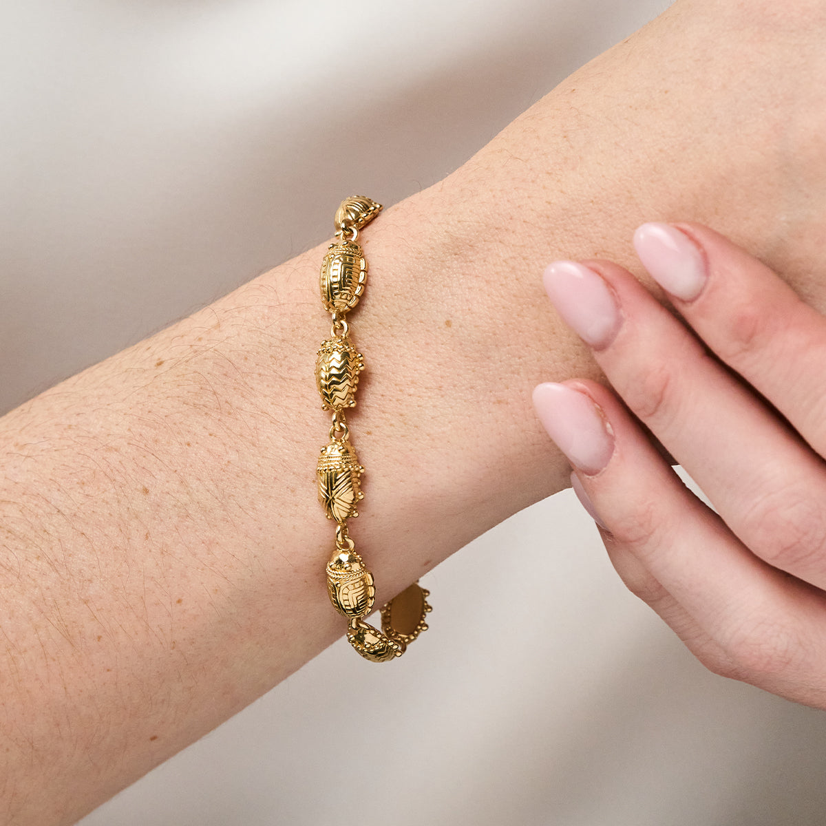 Scarab Petite Linear Link Bracelet, 6"+1" - Gold close up on wrist