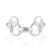 A polished silver cuff featuring a central textured bar flanked by two interlocking circular loops, displayed on a clean white reflective surface.