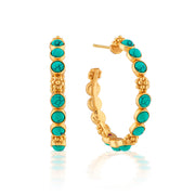 Classic hoop earrings are adorned with vibrant turquoise orbs and a sprinkling of golden berries for a look that’s polished, bohemian, and chic. These hoops add a fabulously feminine flourish to any ensemble—whether you’re running a meeting, hosting a dinner party or jet-setting to Santa Fe.