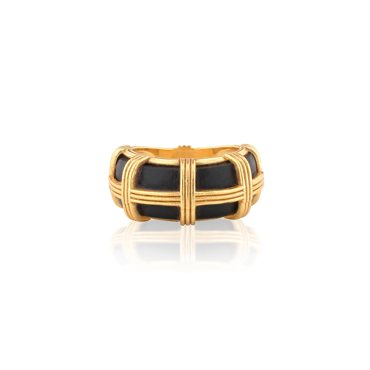A gold-plated ring with a basketweave design enclosing a black enamel inlay, shown on a clean white background with a soft reflection below.