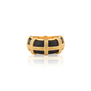 A gold-plated ring with a basketweave design enclosing a black enamel inlay, shown on a clean white background with a soft reflection below.