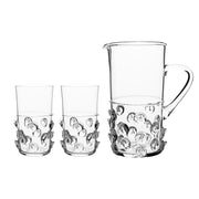 A stunning gift for the person who has everything, this exquisite set of artisanal mouth-blown glass in our historic bohemian 'prunt' motif, is beyond compare. Each piece is signed by our master glass artists and bedecked in indulgent droplets that are opulent, fun, and irresistibly tactile. Certain to spark conversations and make an occasion of any moment, our substantially sized pitcher and matching duo of highball glasses come beautifully packaged in our signature Juliska gift box. Cue the fanfare.