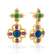 A pair of gold dangle earrings with green, blue, and purple gemstones, displayed on a clean white background with a soft reflection.