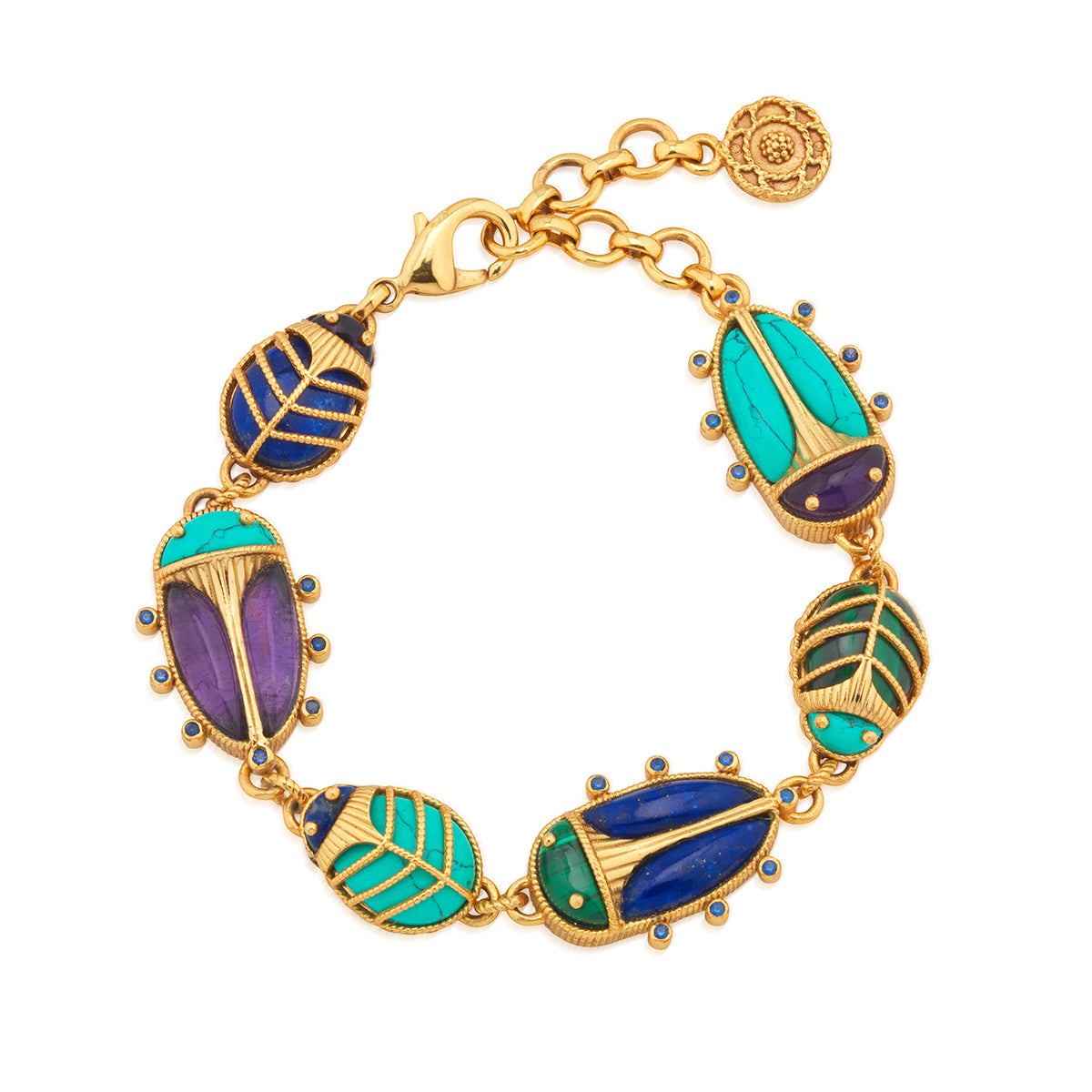 A family of colorful scarabs align to create this statement link bracelet that never fails to spark conversation. Like little jewels of the desert, these charming creatures are trimmed in intricate golden details, from their gilded exoskeletons to tiny feet, with vibrant hand-carved wings and heads of polished amethyst, lapis, malachite and turquoise. They playfully flip throughout the day to reveal underbellies of bright gold with a radiant sunburst motif.