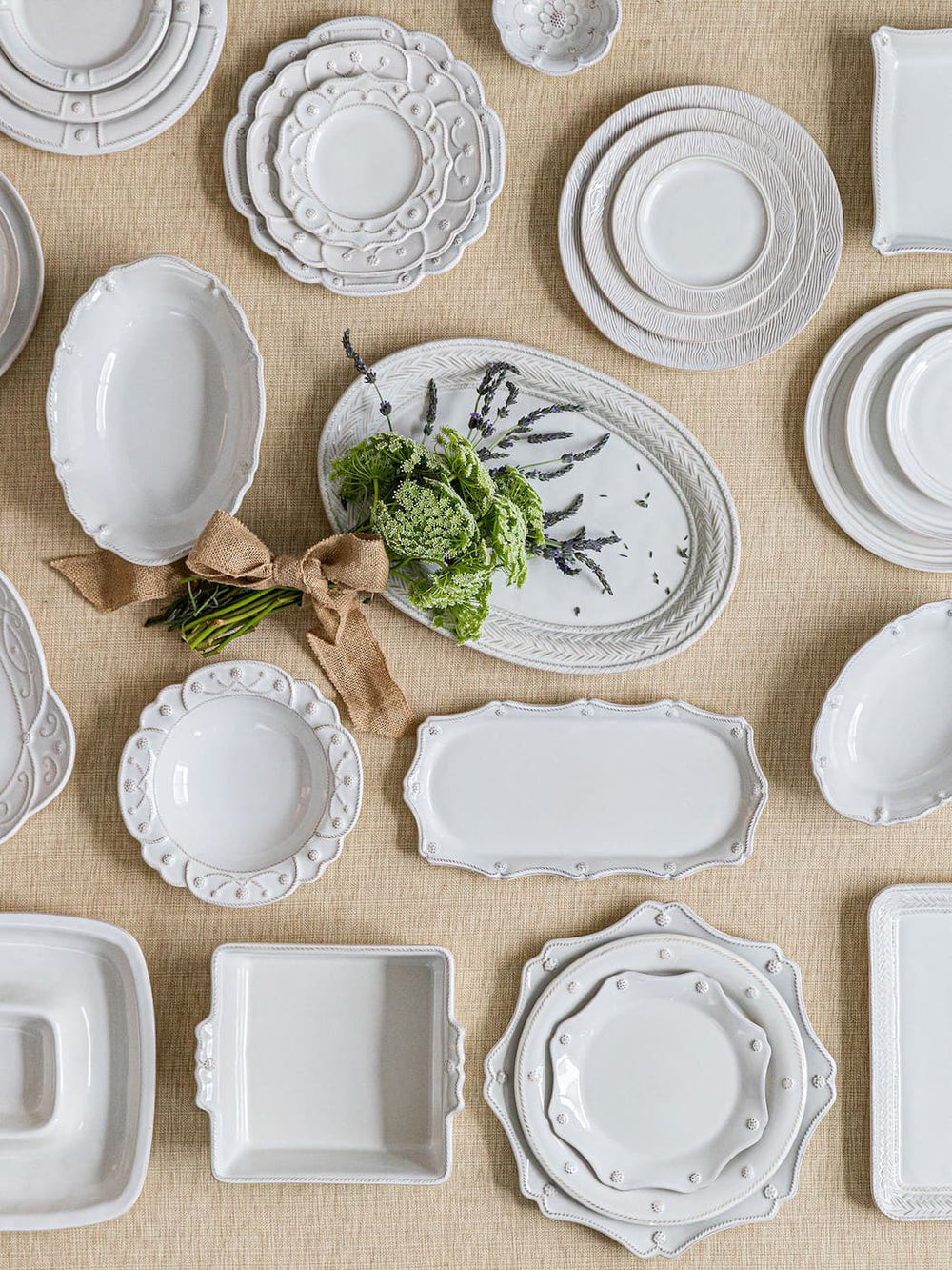 Collection of white ceramic dishes on a beige surface
