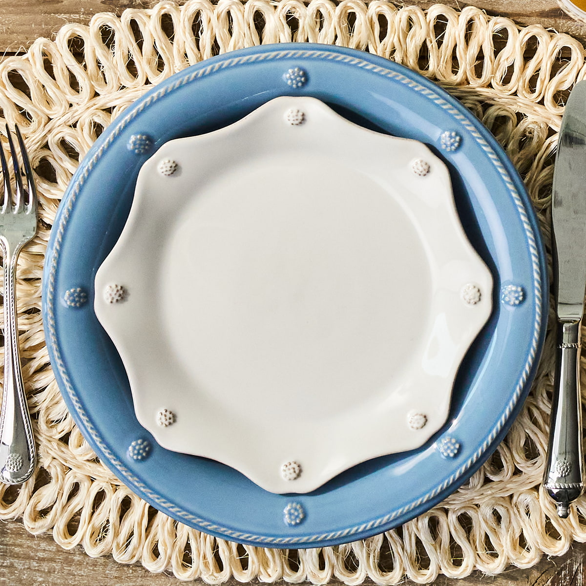 Set of blue and white ceramic plates on a woven placemat with silverware.