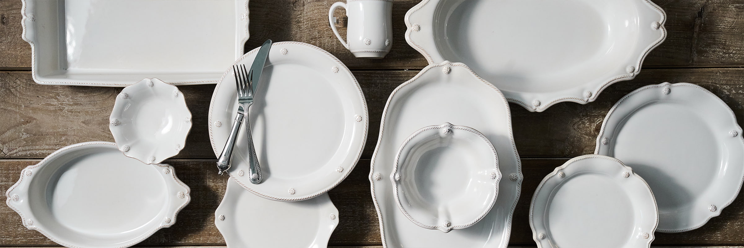 Set of white ceramic dishes on a wooden surface