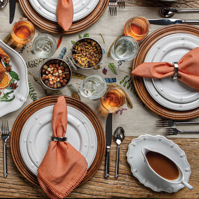 Dining table set for a meal with plates, napkins, and glasses.