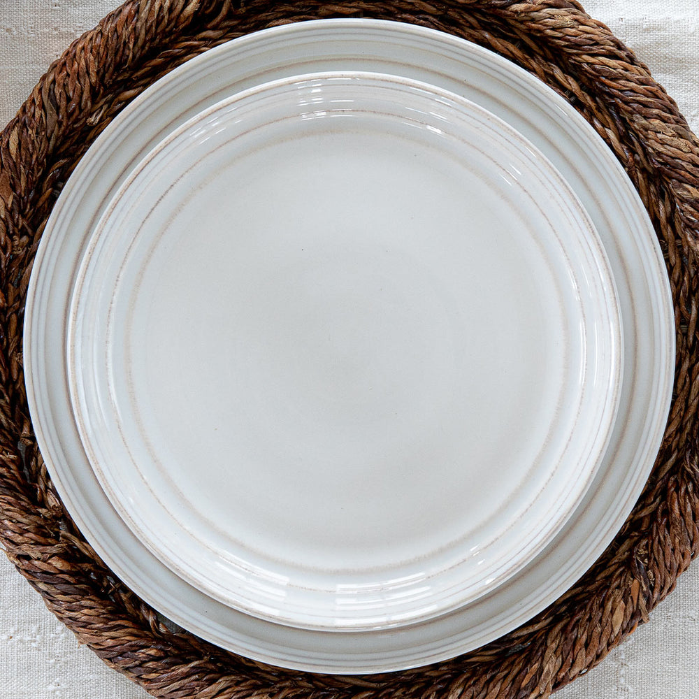 Bilbao Whitewash collection stacked plates on a brown charger.