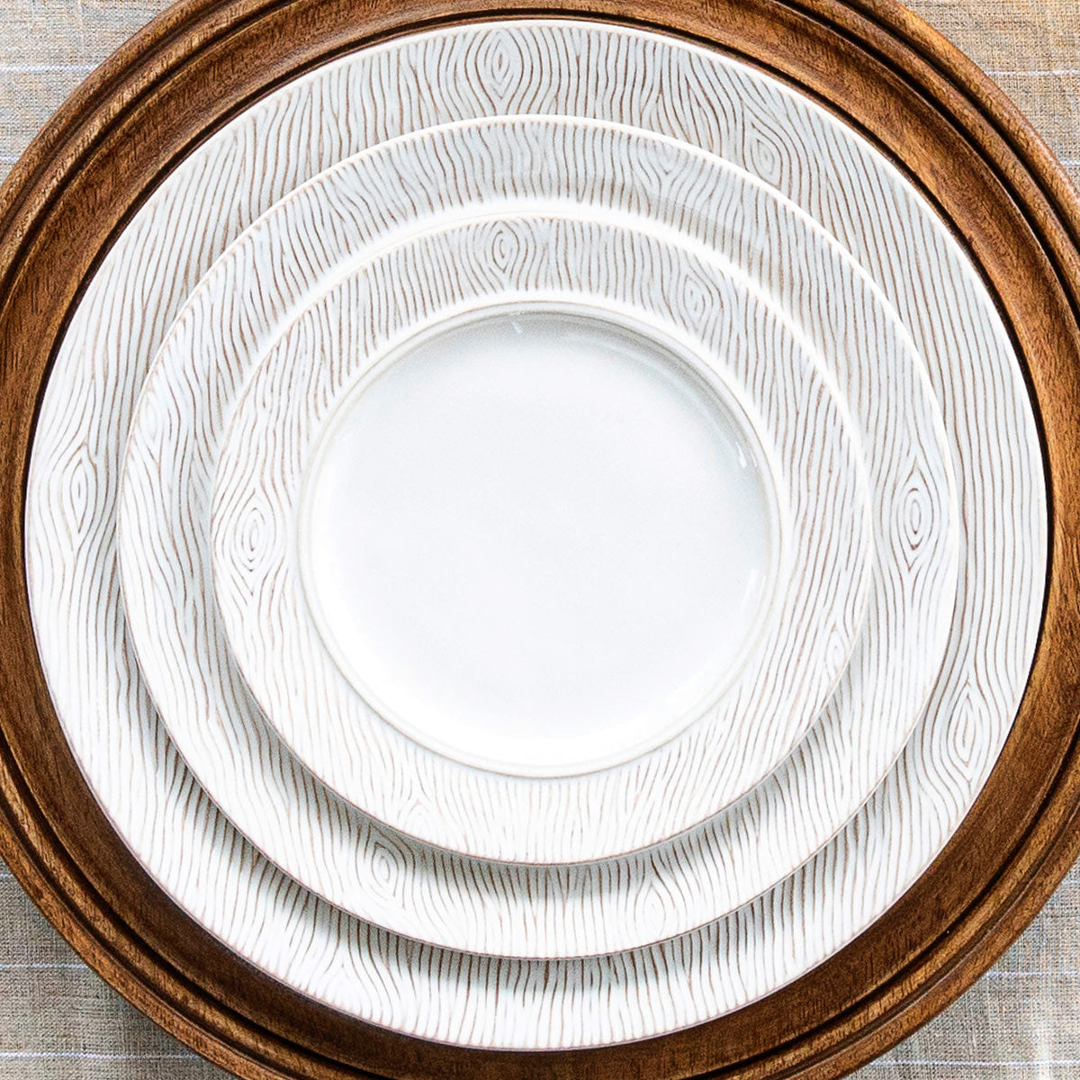 Three blenheim oak plates stacked on a wood charger