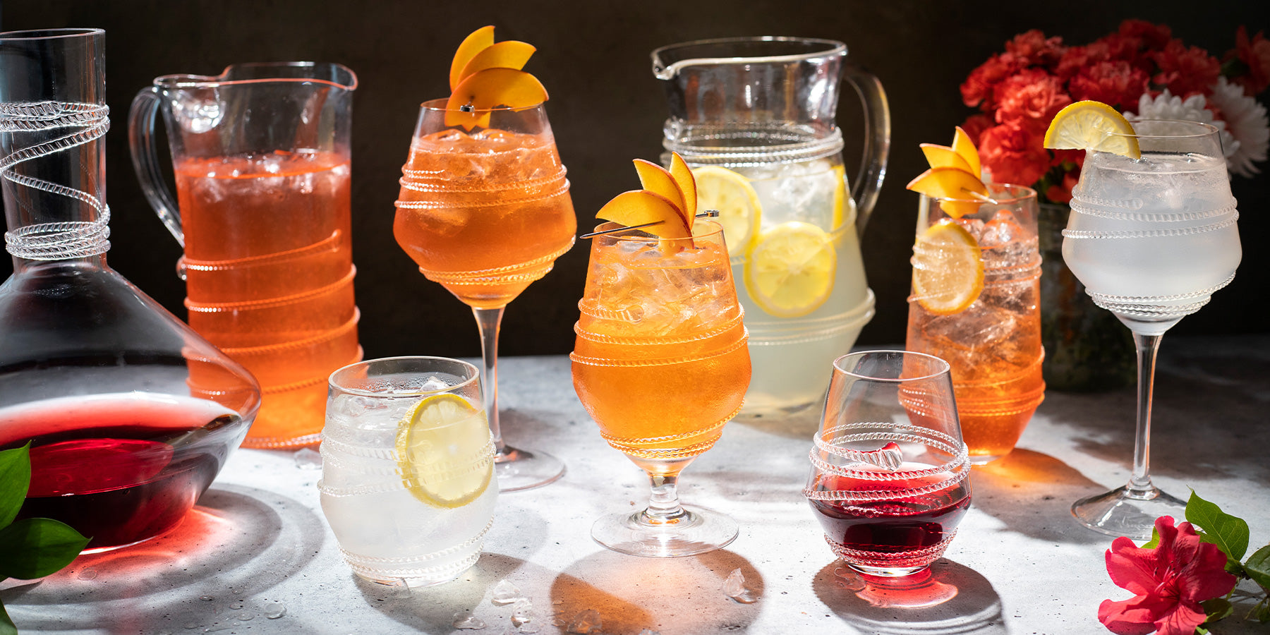 Chloe glass with orange cocktails and lemon ice water in a pitcher.