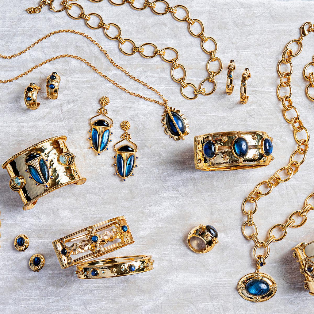 Gold and blue jewelry on a white cloth.