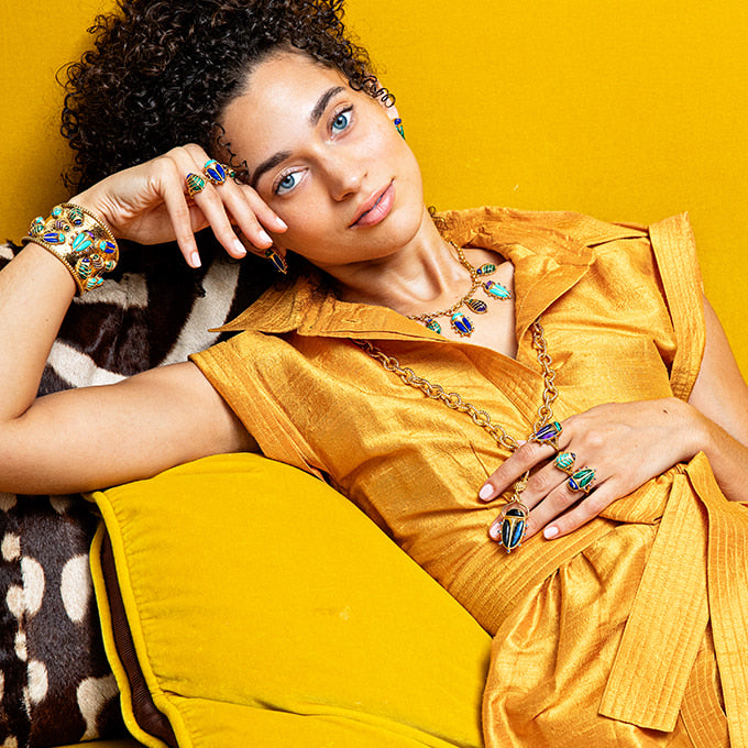 Woman wearing colorful jewelry against a yellow background