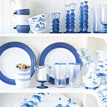 Open shelving pantry showcasing white and blue ceramic and glass tableware.