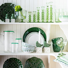 Open shelving pantry showcasing white and green ceramic and glass tableware.