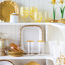 Open shelving pantry showcasing white and yellow ceramic and glass tableware.