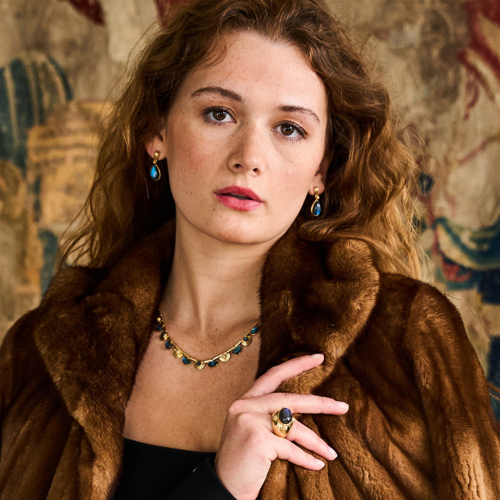 Woman wearing fur coat modeling blue labradorite jewelry