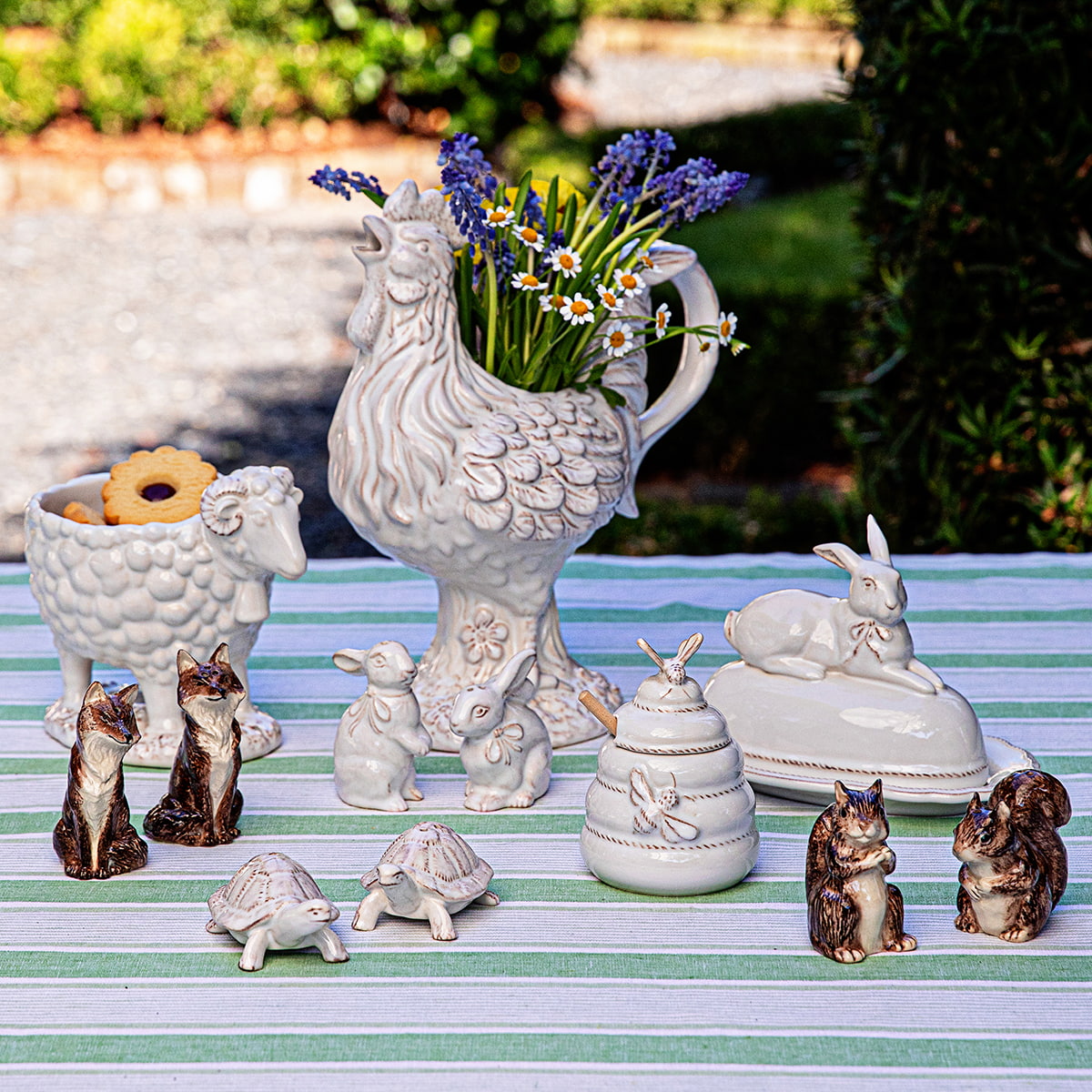 A whimsical bud vase sits next to a beautifully hand-sculpted ram and animal salt and pepper shakers