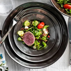 Bright green colored salad leaves pop against the lustrous pewter colored glaze of three stacked Pewter Stoneware plates.