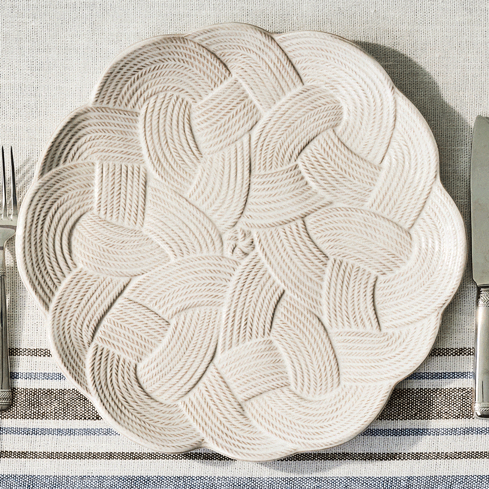 Moveable gif featuring stack of white and blue plates on a textured tablecloth