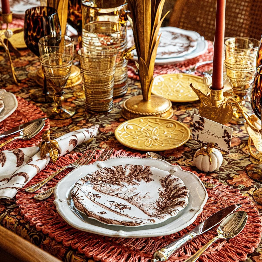 Decorative Thanksgiving table setting with plates, glasses, and place cards.