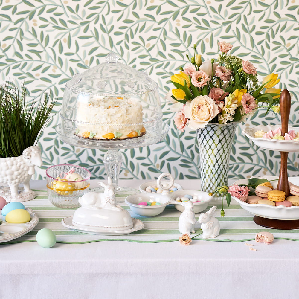 Easter themed tablescape with colored eggs, cake, and macaroons displayed
