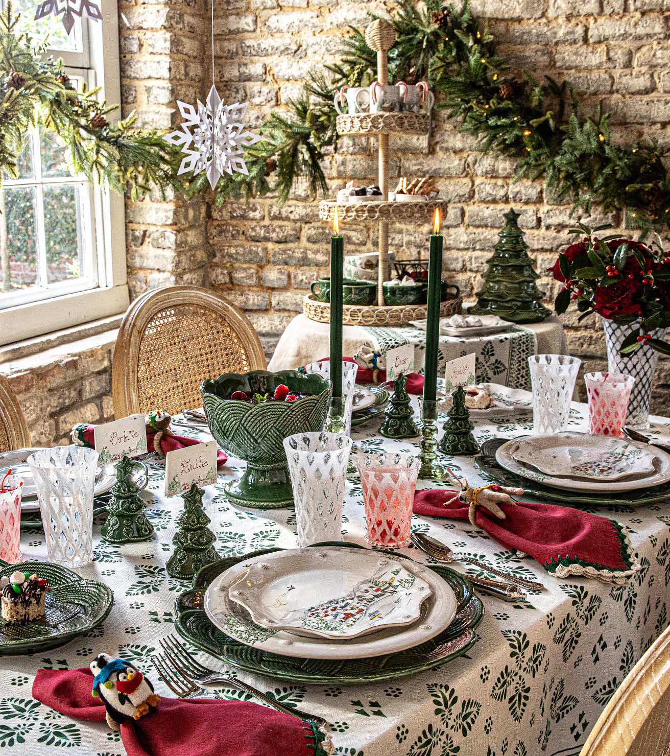 Decorative Christmas table setting with greenery and candles in a cozy room.